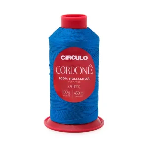 Foto com fundo branco contendo um cone do fio cordonê círculo na cor sombra azul