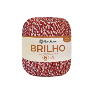 Foto com fundo branco contendo um novelo do barbante euroroma brilho vermelho, branco e dourado